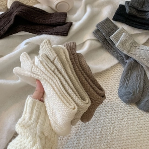 Close-up of assorted cable knit wool blend socks with ribbed cuffs in neutral colors