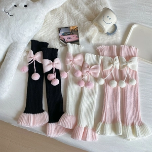 Détail de jambières Lolita avec nœuds mignons et pompons en peluche aux couleurs pastel