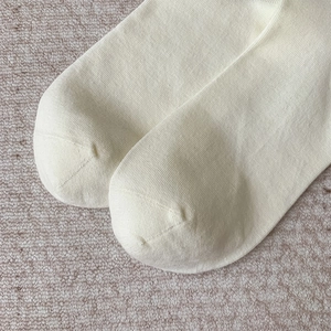 Gros plan des coutures sans couture aux orteils des chaussettes hautes en tricot écru