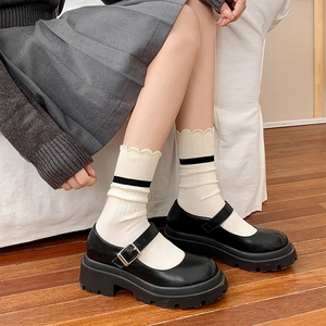 Classic black matte Mary Jane platform shoes with buckle strap and cream striped socks