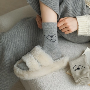 Texture de maille détaillée des chaussettes grises avec motif ours et bordure côtelée