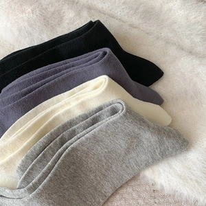 Détail de chaussettes hautes côtelées en plusieurs couleurs sur tapis en fausse fourrure