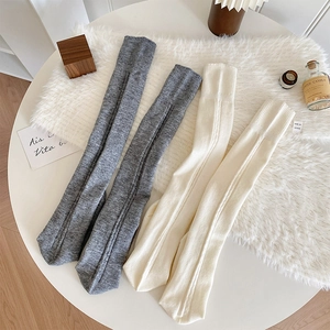 Détail de la texture des chaussettes montantes en maille épaisse grise et beige