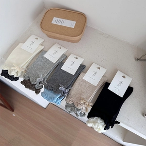 Detail of five pairs of cotton knit socks with elegant bow ties and ruffled edges