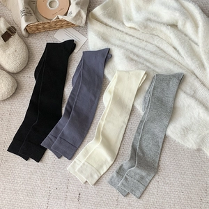 Mise à plat de quatre paires de chaussettes hautes en tricot noir, bleu, beige et gris
