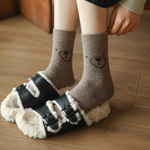 Chaussettes en laine ours japonais avec pantoufles en cuir peluche sur sol en bois
