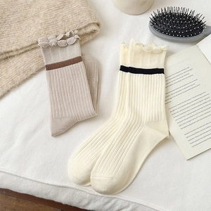 Detailed view of women's ribbed knit crew socks with lettuce trim edge and stripes