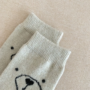 Gros plan d'un motif d'ours mignon sur des chaussettes chaudes en laine tricotée