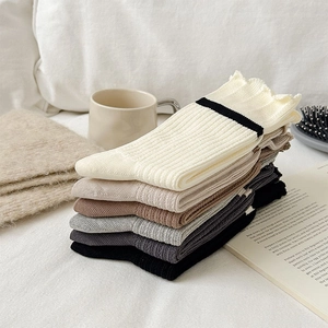 Macro detail of ribbed knit socks with elegant ruffled cuffs in various Morandi colors