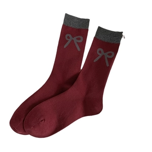 Retro burgundy crew socks with grey bow print and striped cuff design on white background