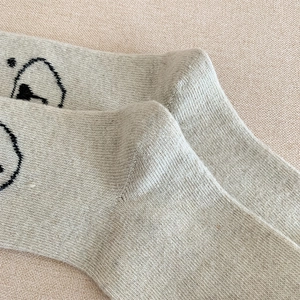 Détail de la maille douce et du motif d'ours sur d'épaisses chaussettes en laine