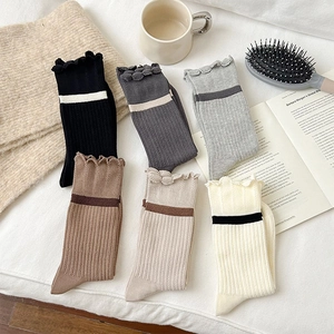 Detail showing set of six colorful mid-calf socks with ruffle trim and rib knitting