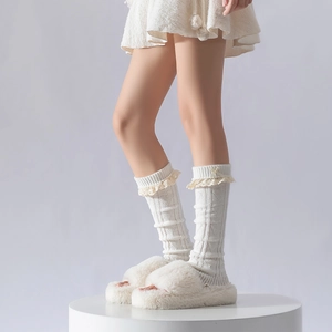 Détail de jambières en tricot crème avec bordure en dentelle et nœuds élégants