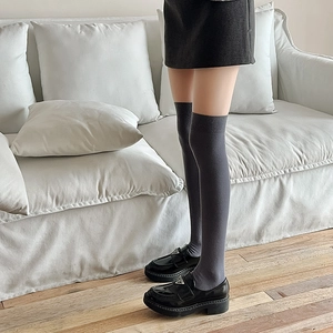 Détail de chaussettes hautes gris foncé en maille avec revers côtelés et mocassins