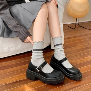 Classic black Mary Jane shoes with thick soles paired with grey striped crew socks