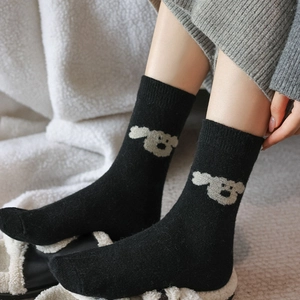 Gros plan détaillé sur la maille épaisse en laine et broderie chien sur chaussettes noires
