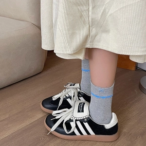 Detail of embroidered blue bow and wavy lace trim on grey vintage crew socks
