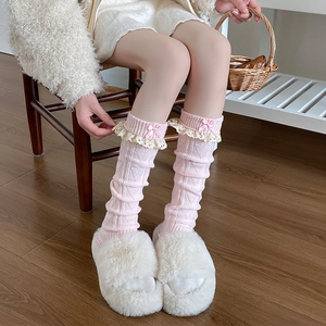 Détail de jambières en tricot rose avec dentelle délicate et nœuds en ruban