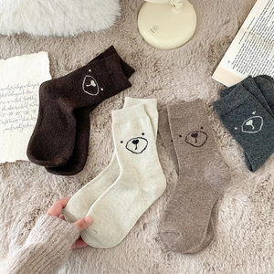 Vue détaillée de quatre paires de chaussettes en laine avec têtes d'ours brodées