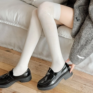 Chaussettes montantes blanches tricotées avec mocassins plateforme noirs en cuir et décor métal