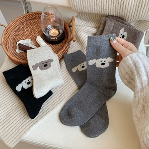 Gros plan d'une broderie de chien sur des chaussettes épaisses en laine aux tons neutres