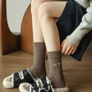 Close-up of thick coffee brown wool socks featuring cute dog embroidery and knit texture