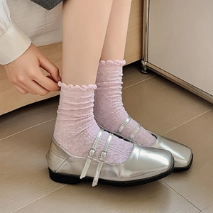 Detailansicht der silbernen Mary Jane Schuhe mit Doppelriemen und lila Spitzen-Socken