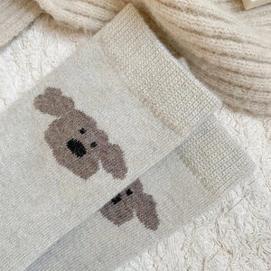 Gros plan de chaussettes en laine gris clair avec motif de caniche mignon et épais