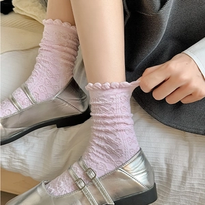 Detail von rosa Spitzen-Rüschensocken mit Lochstrickmuster und silbernen Lackschuhen