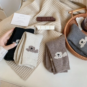 Détail de quatre paires de chaussettes en tricot chaud beige et marron brodées ours