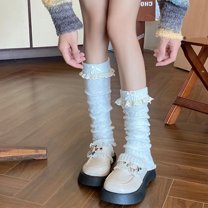 Détails rapprochés de jambières blanches en tricot avec dentelle et petits nœuds
