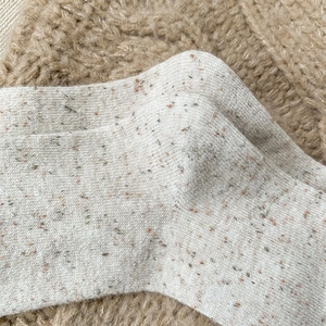 Close-up of wool socks with colorful flecks and vintage tweed knit texture detail
