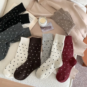 Flat lay of colorful polka dot wool socks in various warm autumn colors with ribbed cuffs