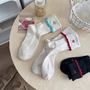 Detail view of ribbed knit socks with lace trim and elegant butterfly embroidery