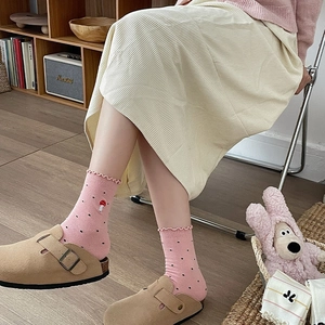 Detailed view of pink bow socks with mushroom embroidery and ruffle trim edges