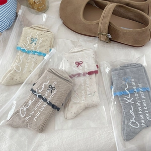 Detailed view of women's lace socks with bow embroidery in premium zipper bags