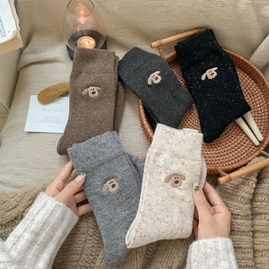 Close-up of thick knitted wool socks with colorful nep yarn and cute dog embroidery