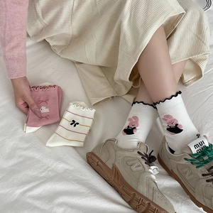 Detail of sweet knit socks featuring frilled cuffs and cute embroidery patterns