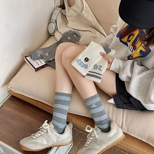 Detail of cotton crew socks showing blue-grey stripes and cute bear embroidery details
