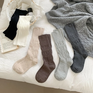 Close-up of six-color vintage ribbed knit crew socks displayed in a cozy home setting