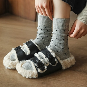 Detail of black leather double buckle plush slippers with warm white faux fur lining