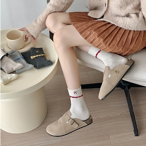 Detail of white knit socks with red bow embroidery and scalloped edges for women