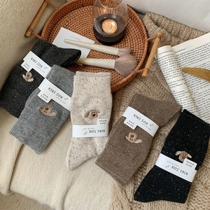 Detail of wool socks with dog embroidery in five colors and winter cozy knit texture