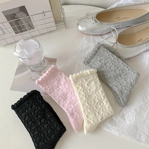 Detail von Rüschensocken mit Schleifentextur in Schwarz, Rosa, Beige und Grau