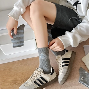 Detailed view of gray cotton crew socks with blue stripes and embroidered ART lettering