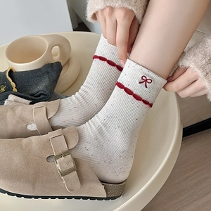 White ballet-style socks with red bow embroidery and colorful confetti dot pattern