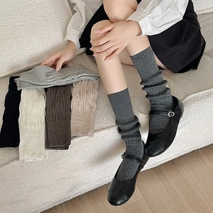 Detailed vertical knit texture of soft slouch socks paired with classic black leather shoes