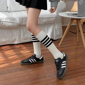 Calze bianche stile giapponese con strisce nere abbinate a scarpe da ginnastica nere