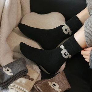 Détail de chaussettes thermiques en laine avec motif d'ours blanc et texture tricotée douce