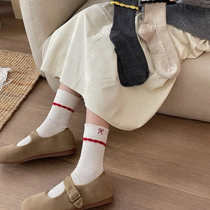 Detail of sweet lace-edge socks with bow embroidery and colorful confetti texture